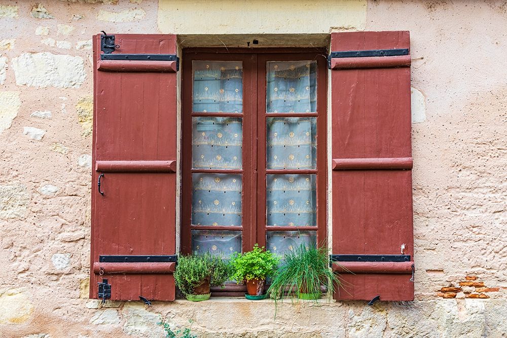 France-Dordogne-Hautefort A brown shuttered window on a house in the town of Hautefort